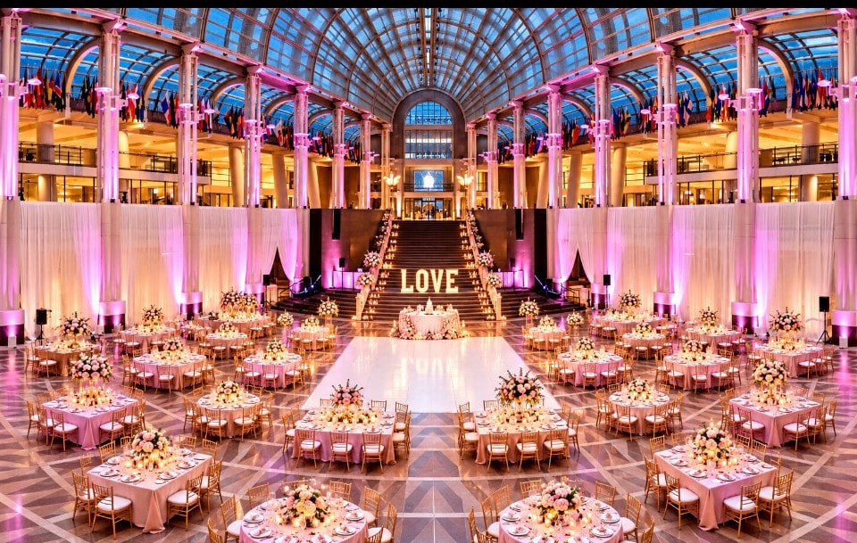 Grand ballroom gala with pink lighting and dance floor