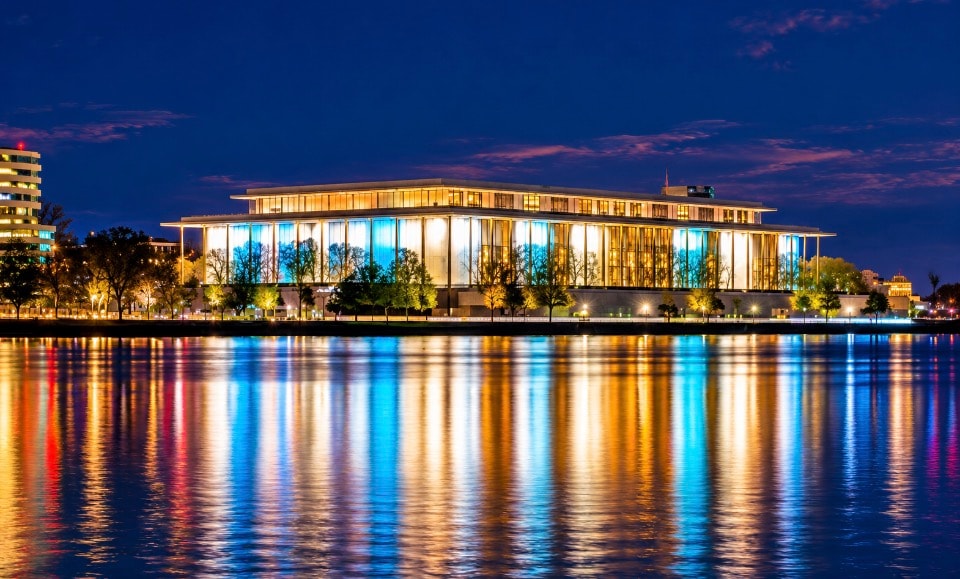 Kennedy Center for the Performing Arts at night with golden and blue reflections on the Potomac River