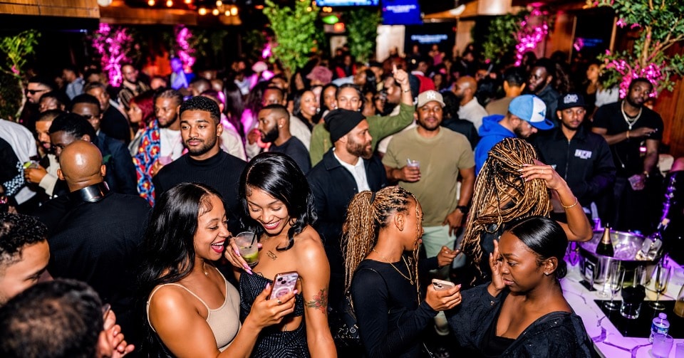 Crowded DC nightclub with purple lighting and festive atmosphere