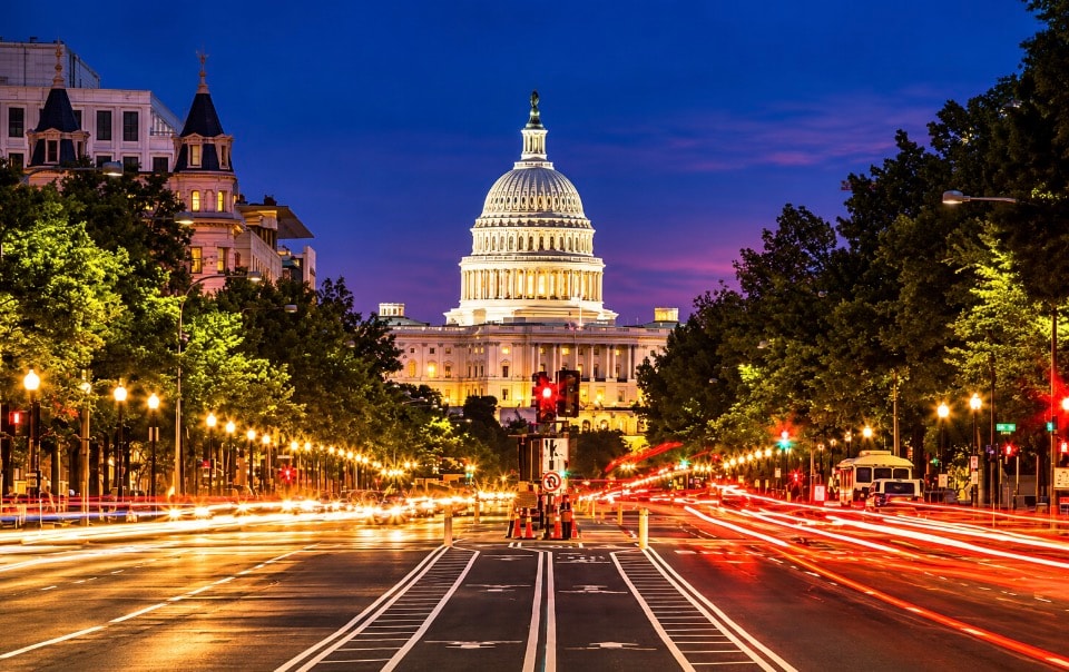 US Capitol building at night with traffic light trails on Pennsylvania Avenue